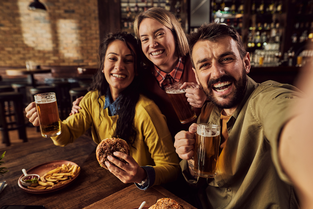 three friends dining at a burger and beer restaurant 