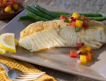 Closeup of a halibut dish served with green beans