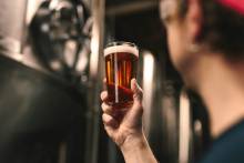 Man holding a beer at a brewery