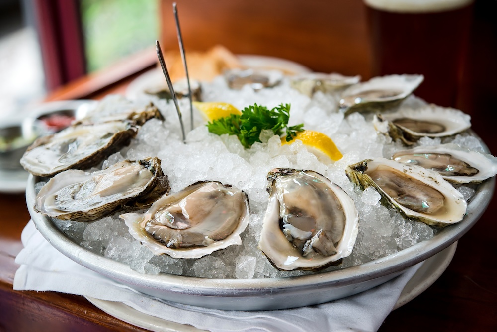 A platter of raw oysters on ice
