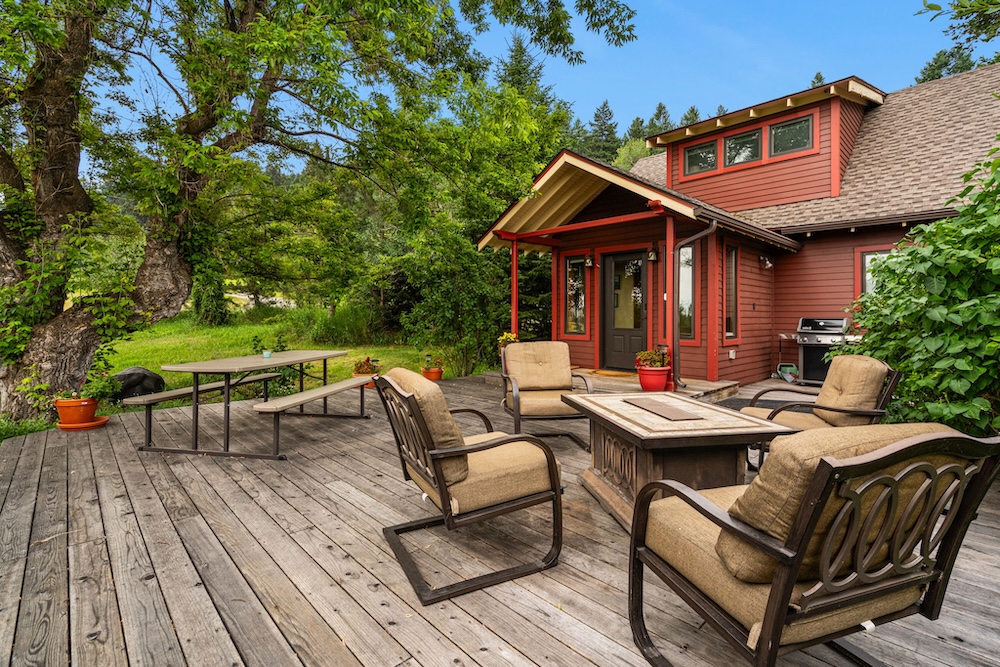 Vacation rental cottage exterior with furnished deck and tree-lined surroundings