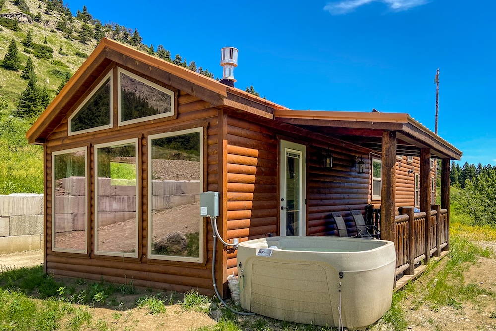 Vacation rental cabin exterior with hot tub and furnished porch