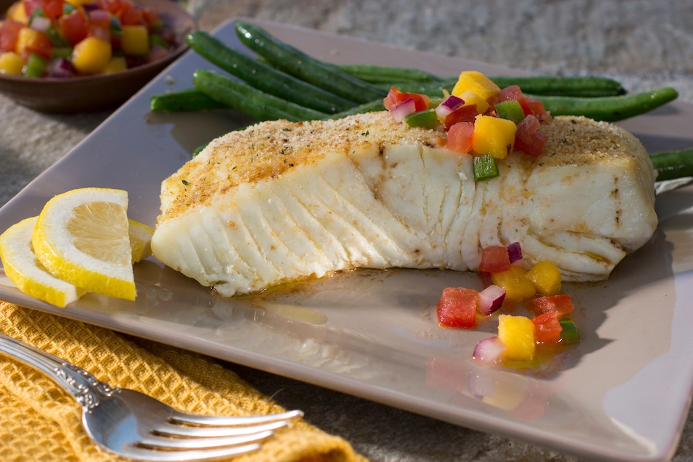 Closeup of a halibut dish served with green beans